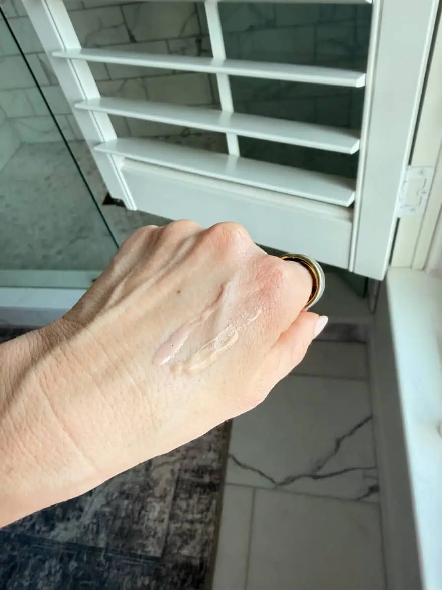 Woman showing Olive Rose HT Pearl Primer Serum on skin