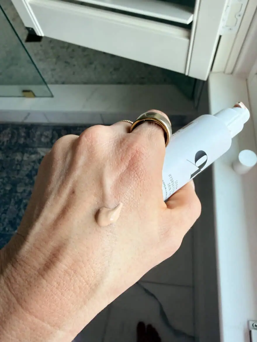 Woman showing hand with a drop of Olive Rose skin tint