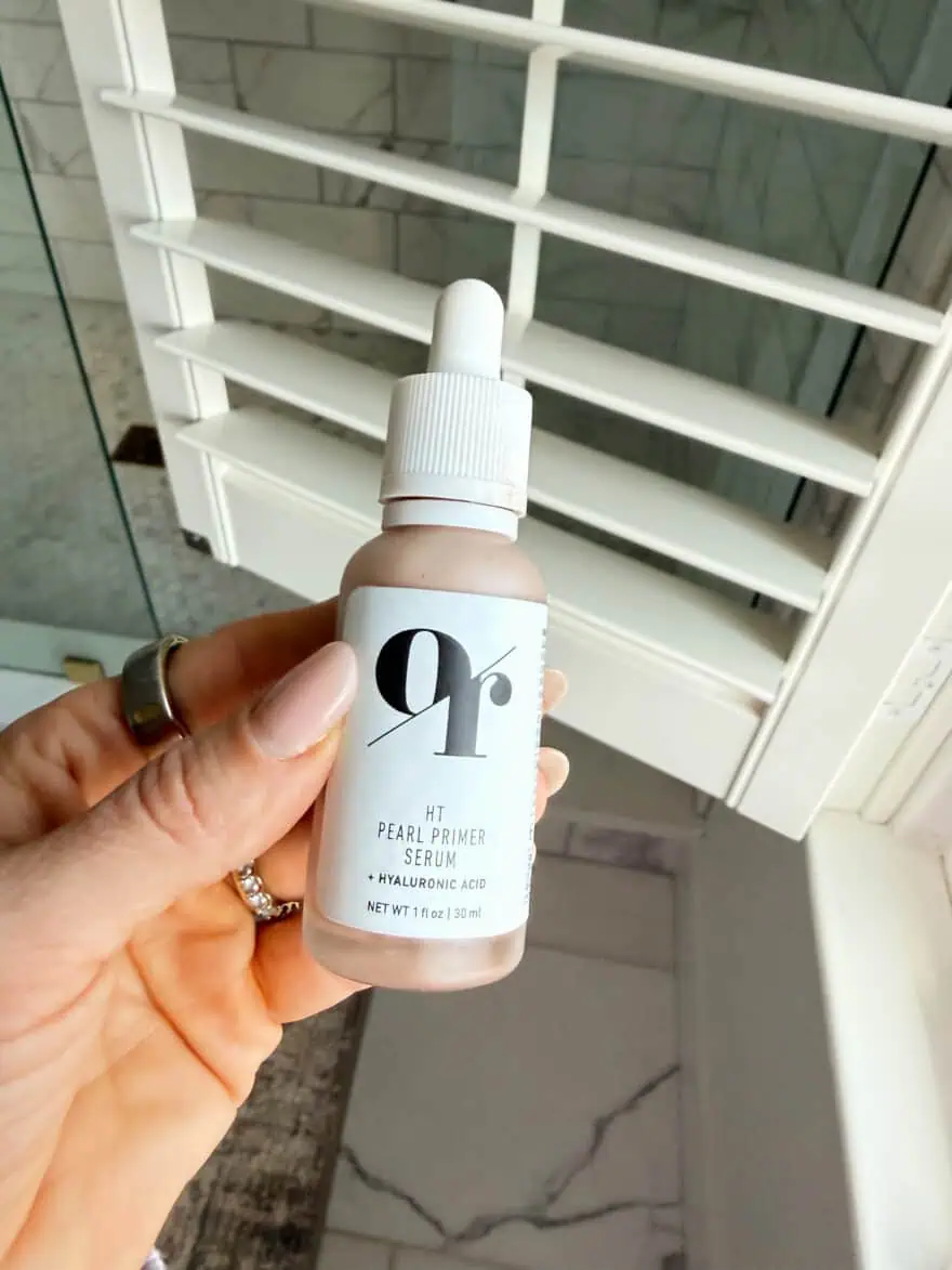 Woman holding bottle of Olive Rose HT Pearl Primer Serum