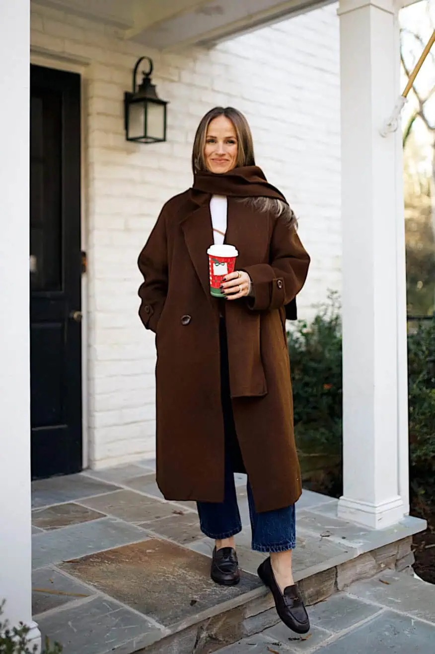 Woman standing on porch while wearing pants and a scarf jacket from Petite Studio