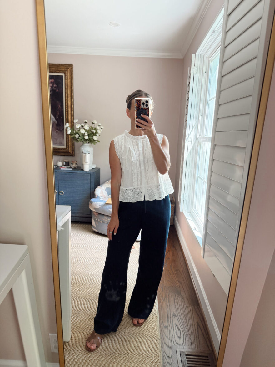 TeriLyn Adams wearing a white eyelet button-front top and navy wide-leg linen pants with tan slide sandals