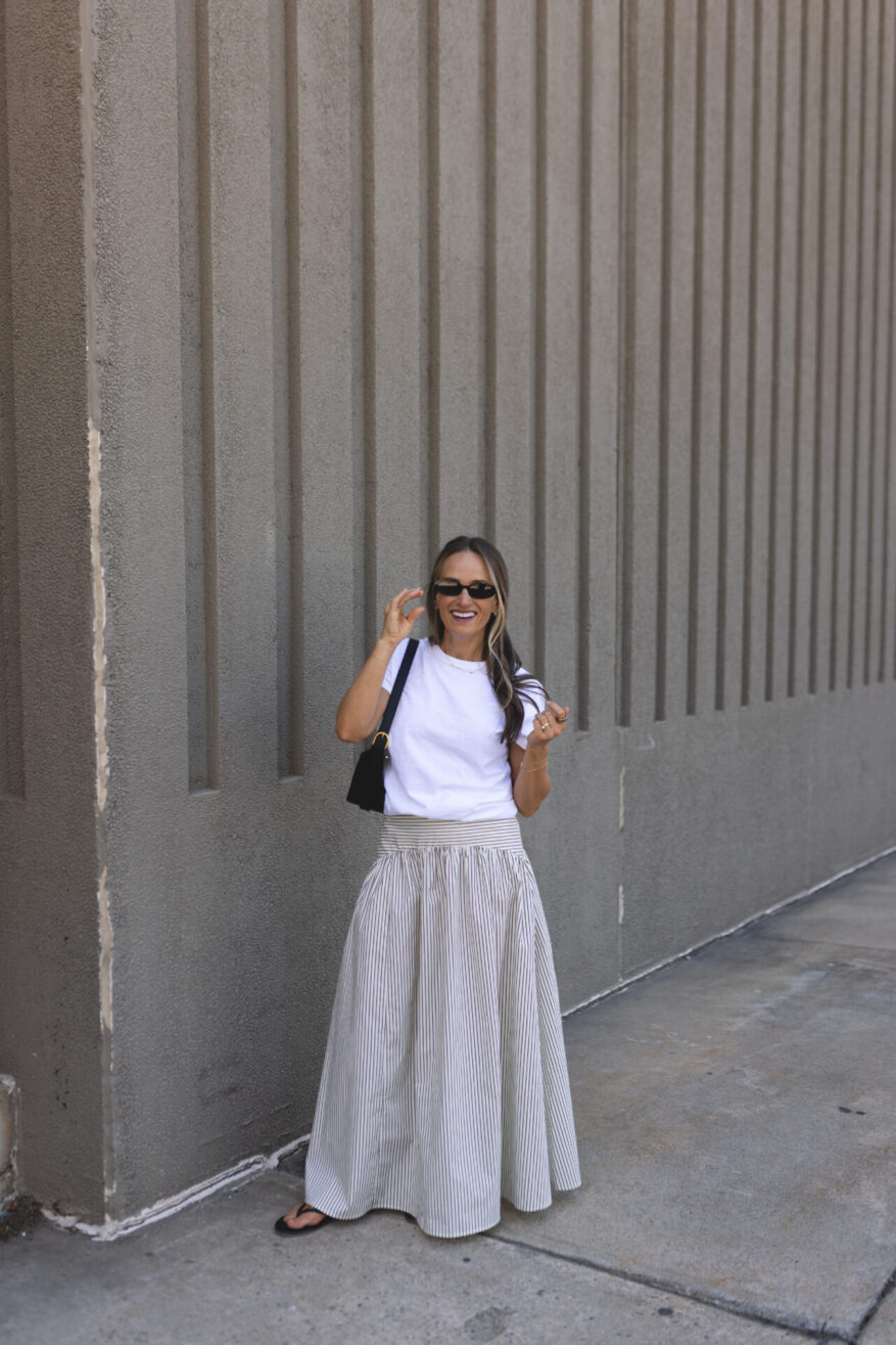 TeriLyn Adams wearing a white crewneck tee and striped maxi skirt with flip-flops
