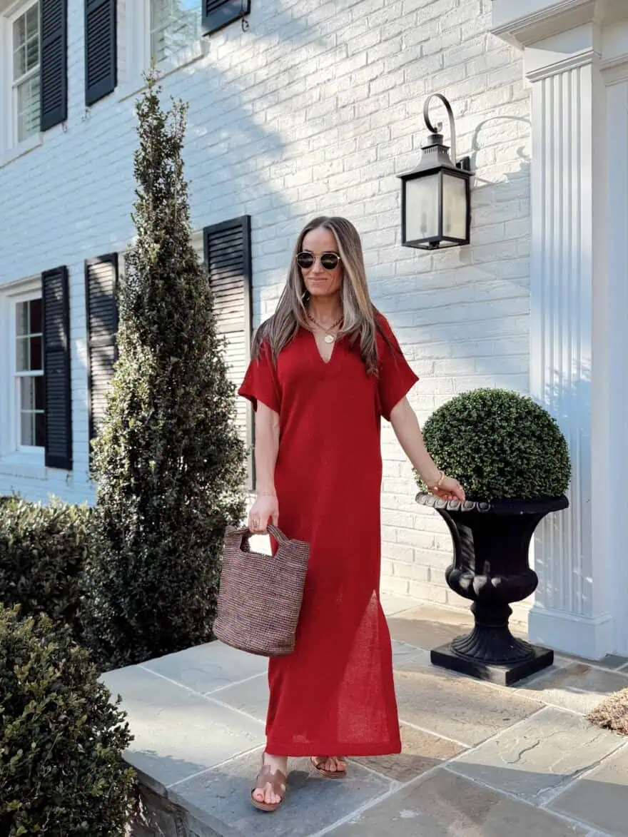 Woman standing on porch wearing red dress