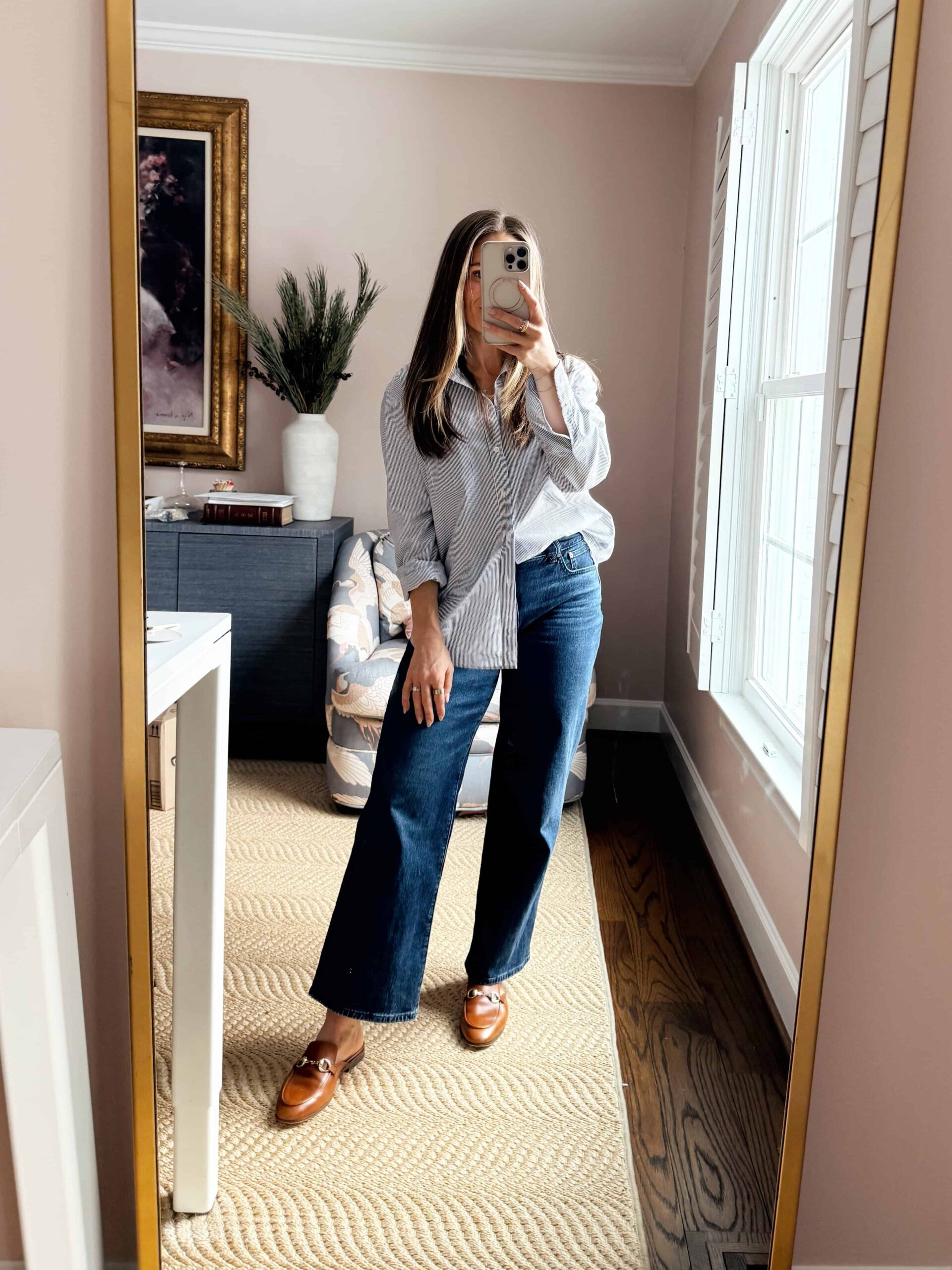 Woman wearing wide-leg jeans with a button up top front tucked