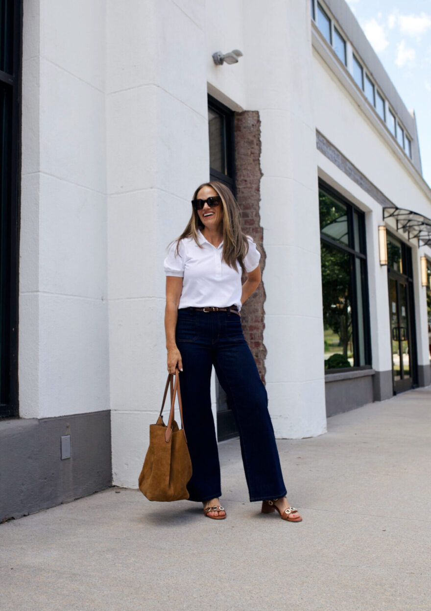 TeriLyn Adams wearing dark wash wide-leg jeans with brown block-heel sandals and a suede tote bag
