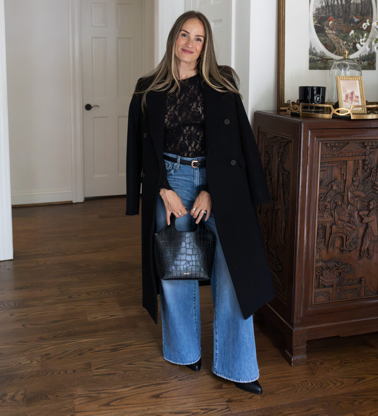 TeriLyn Adams wearing TWP Tiny Dancer High-Rise Wide-Leg Jeans with black pointed-toe boots and a long black coat