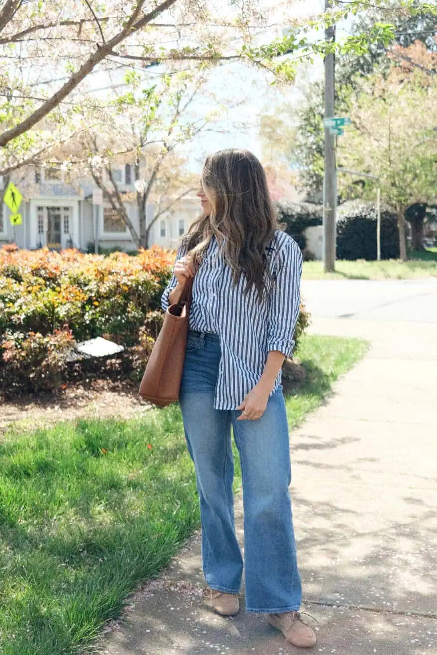 Woman wearing jeans with button-up shirt and boat shoes