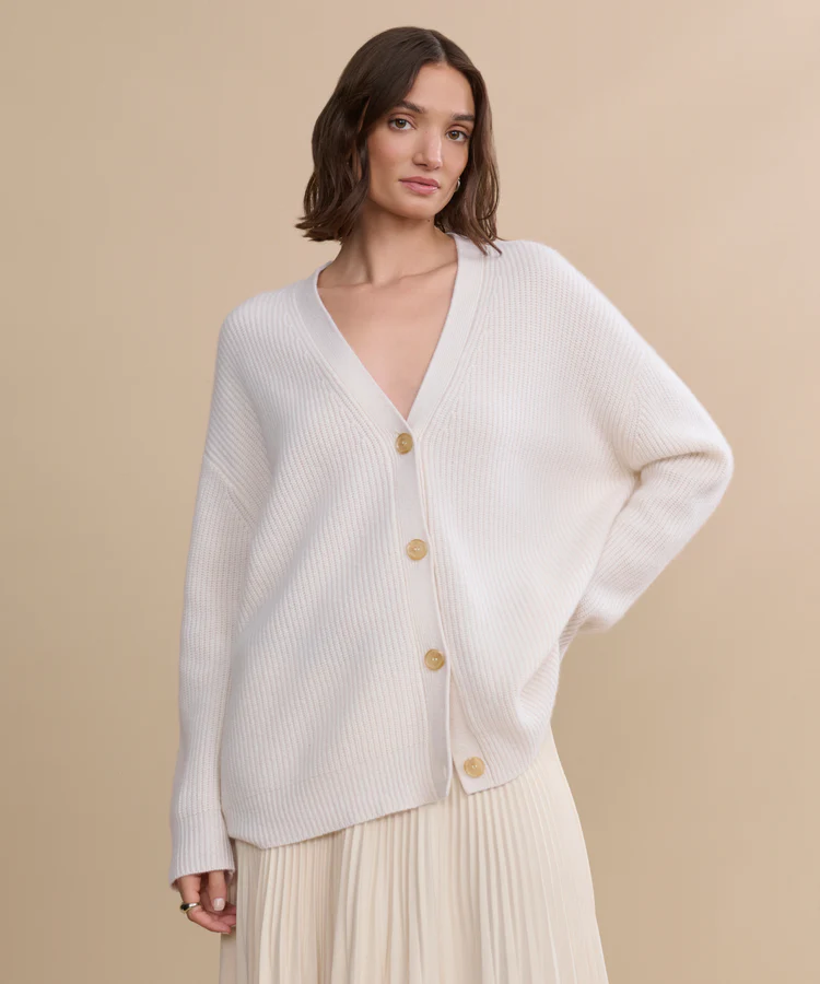 Jenni Kayne ivory cashmere cocoon cardigan styled with pleated skirt
