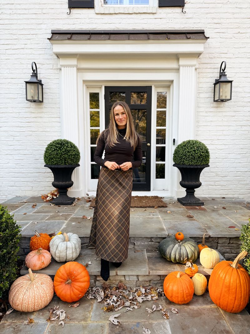 Terilyn Adams wearing a black Everlane turtleneck with a plaid maxi skirt and black boots