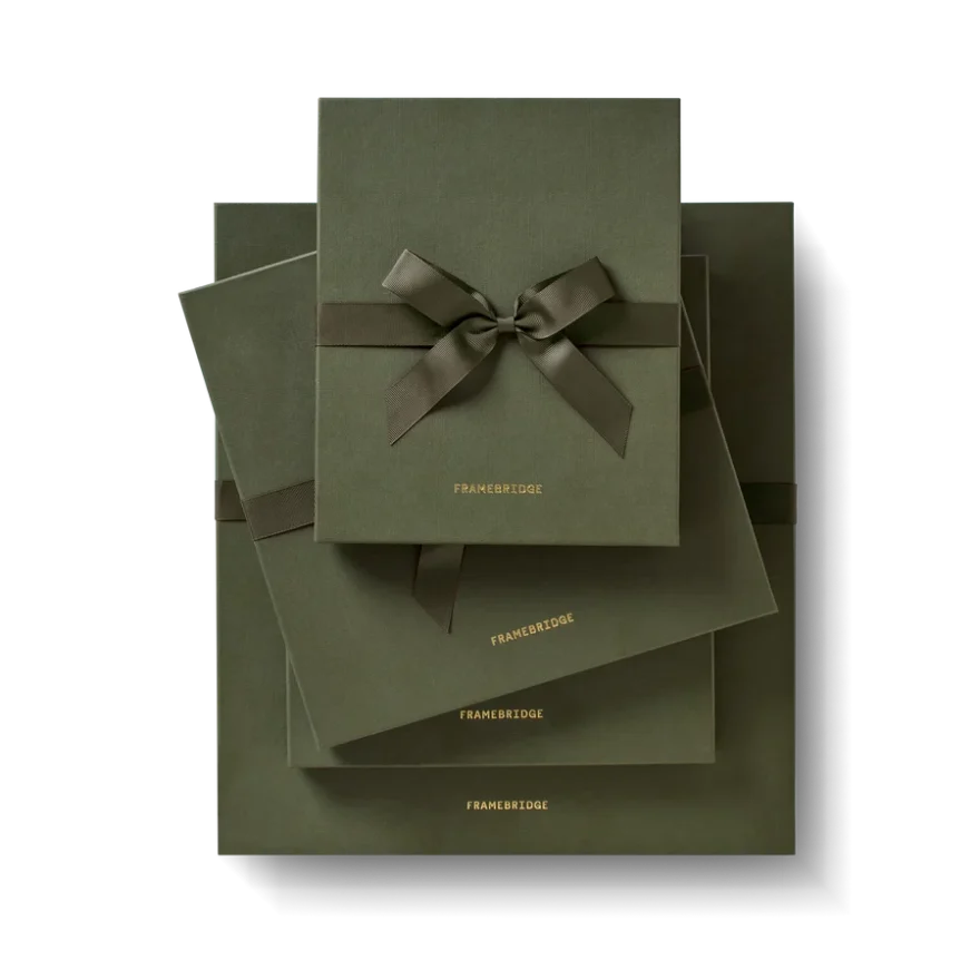 Stack of Framebridge gift boxes tied with ribbon, product shot.