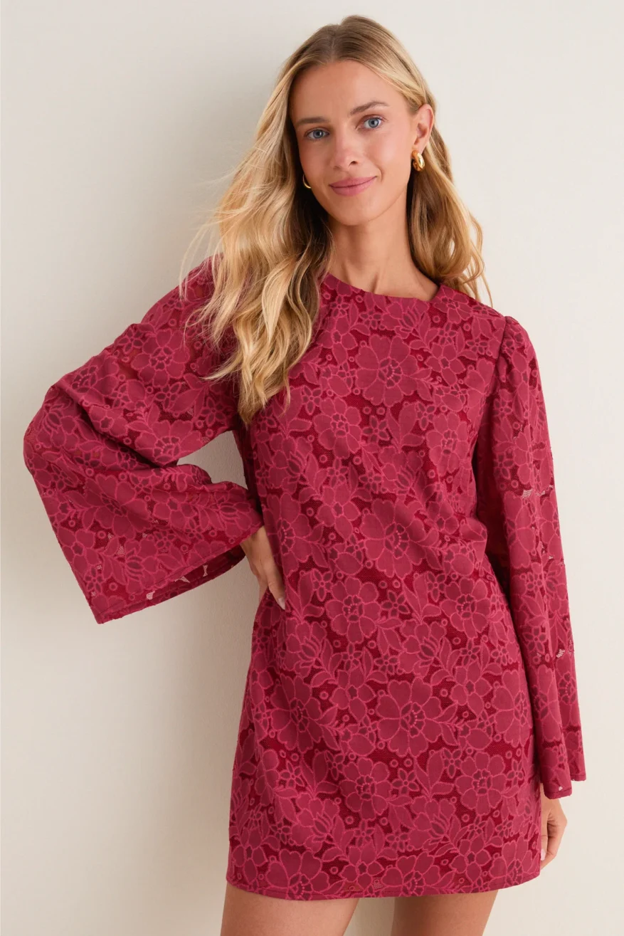 Woman wearing the Hyacinth House Lace Livvy mini dress in deep rose with long voluminous sleeves