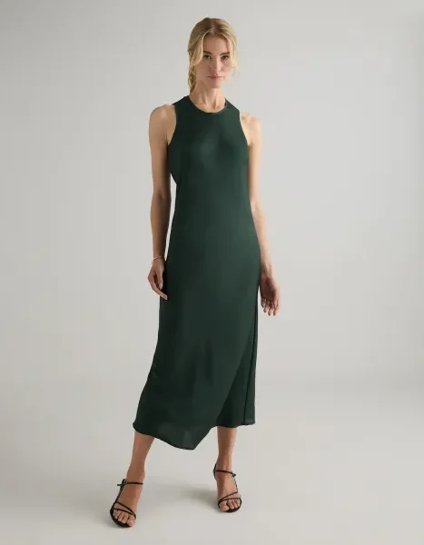 Woman wearing the Quince Washable Stretch Silk tank midi dress in forest green
