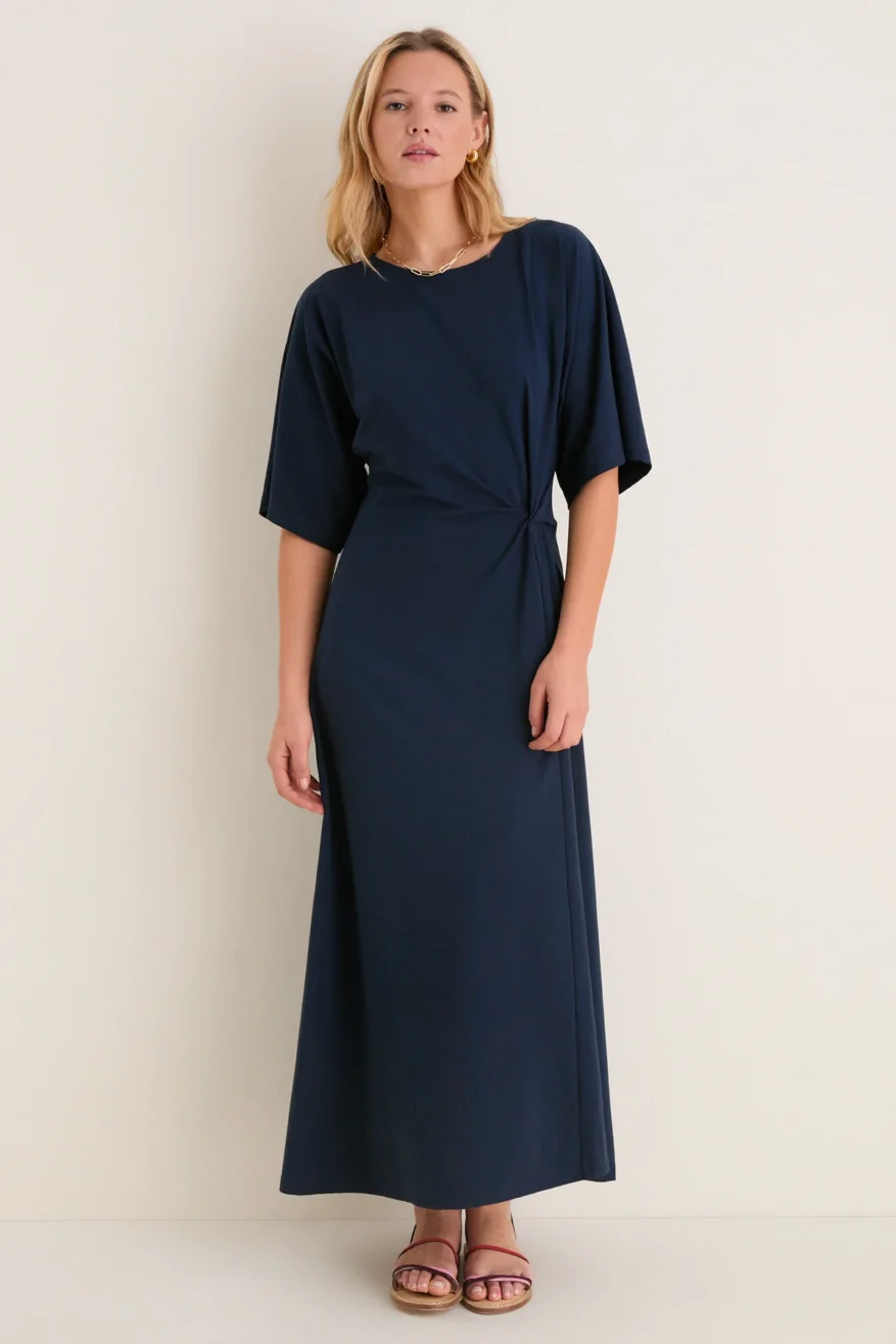 Woman wearing the Tuckernuck Jersey Lisette midi dress in navy with short sleeves and a gathered waist