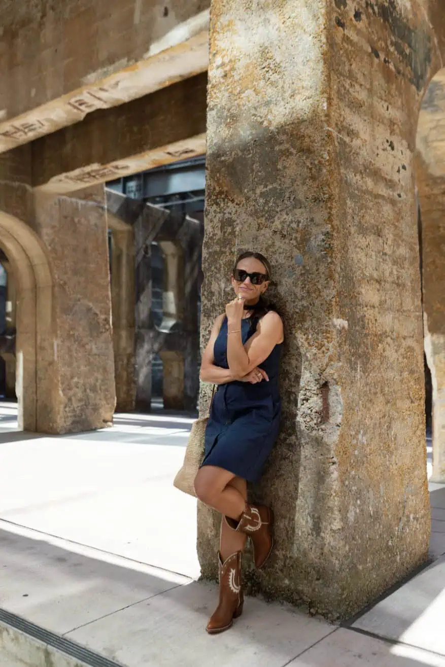 terilyn adams wearing navy tuckernuck dress with buttons and cowboy boots