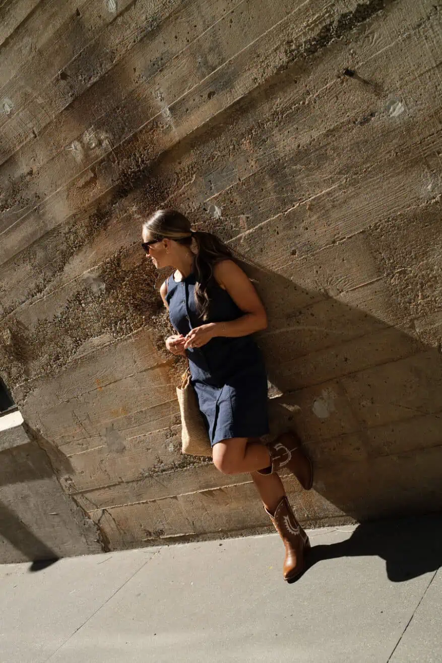 terilyn adams wearing navy tuckernuck dress with buttons and cowboy boots