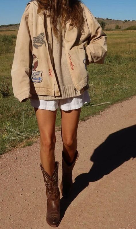 woman wearing a chunky cream sweater with shorts and cowboy boots