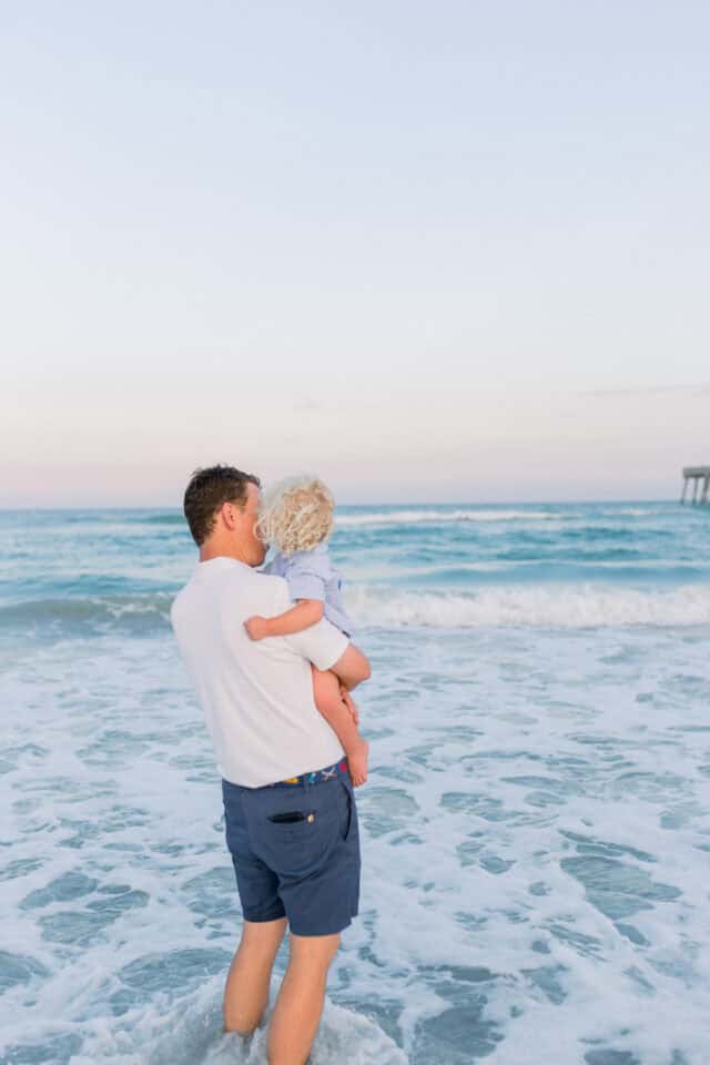 dad holding his son at the beach