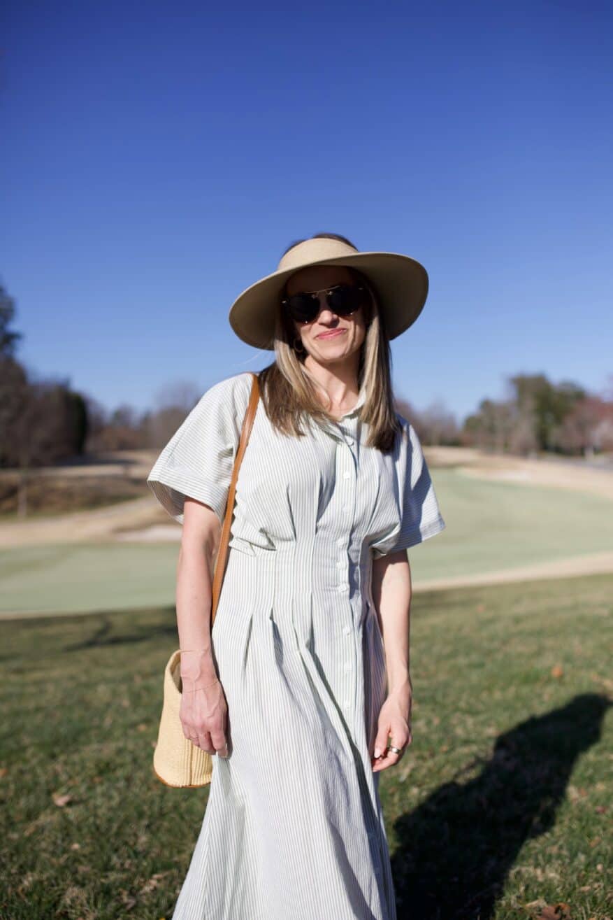 TeriLyn Adams wearing green striped pleated maxi with straw bag and straw hat