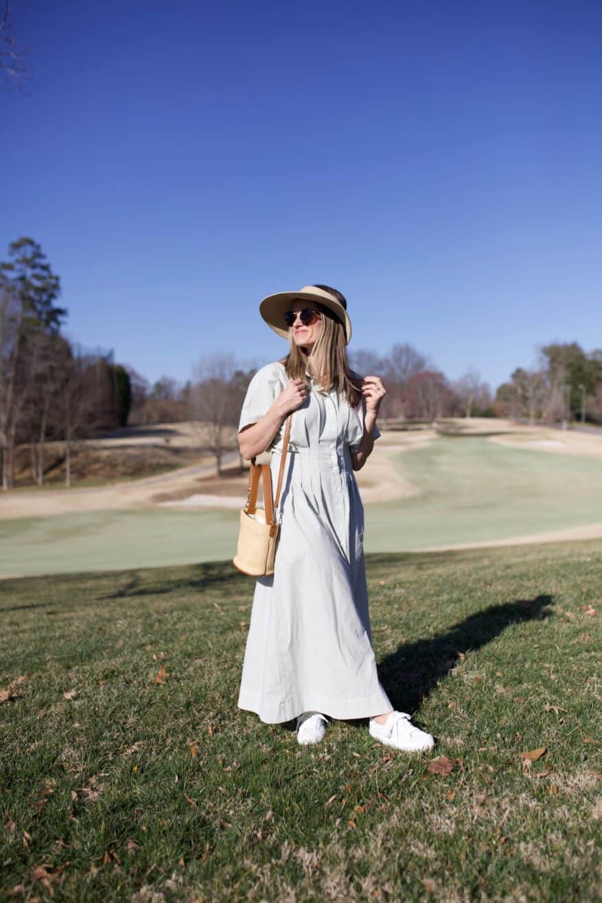 TeriLyn Adams wearing green striped pleated maxi with straw bag and straw hat and white sneakers