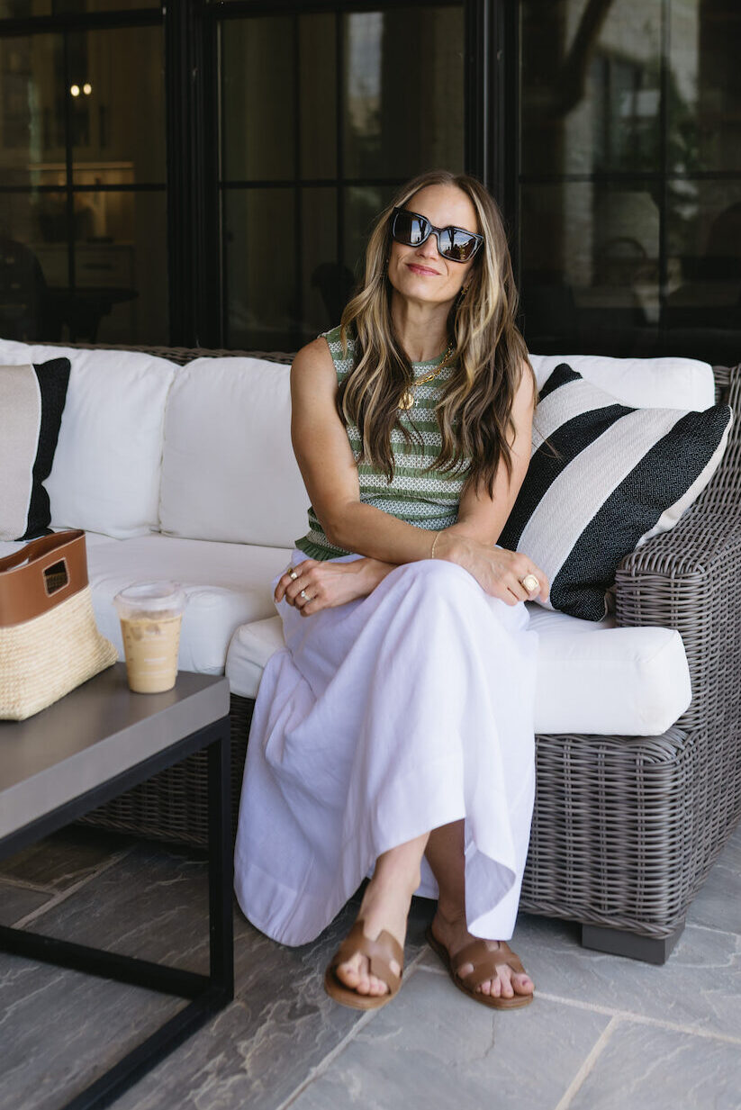 TeriLyn Adams wearing a green striped sleeveless top with a white linen maxi skirt and cognac sandals