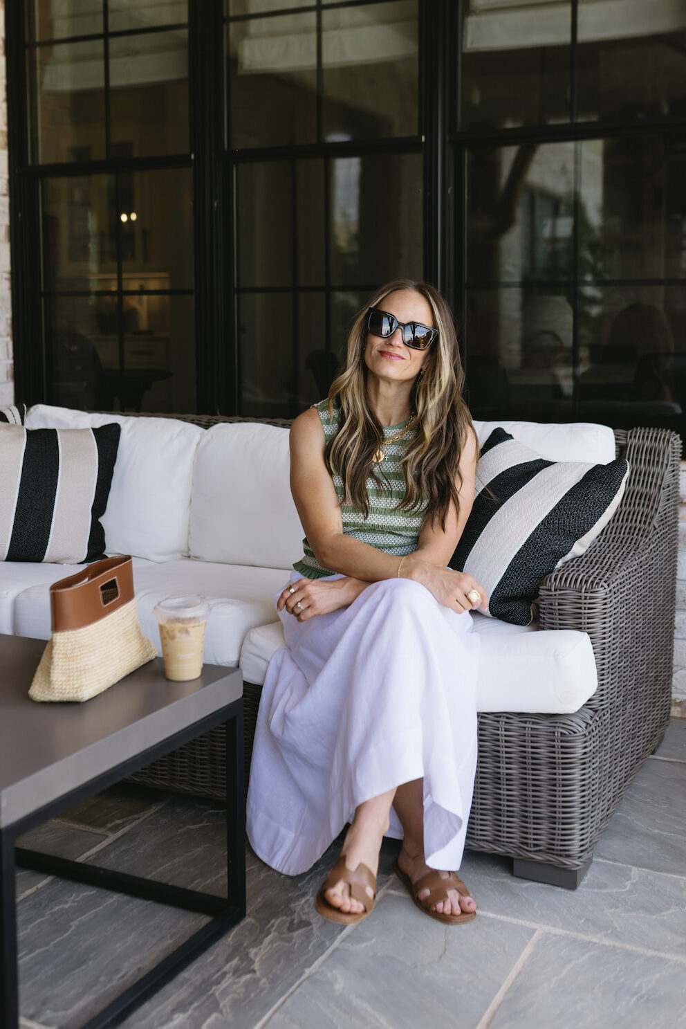 TeriLyn Adams wearing a green striped sleeveless top with a white linen maxi skirt and cognac sandals