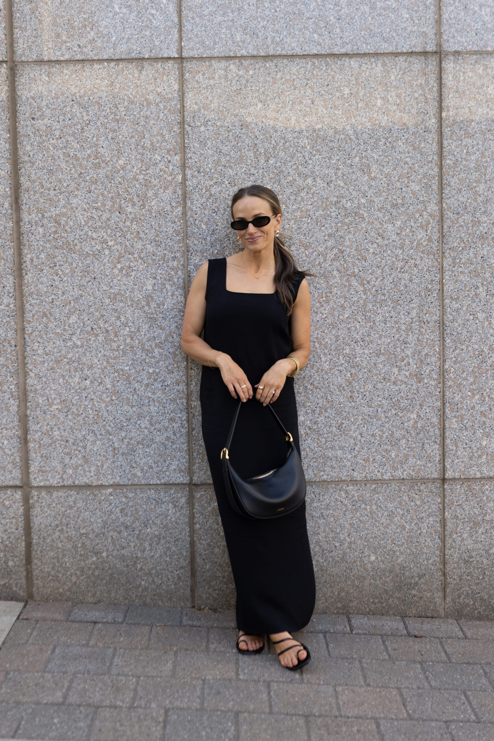 terilyn adams wearing kourt ione black maxi dress holding black leather purse