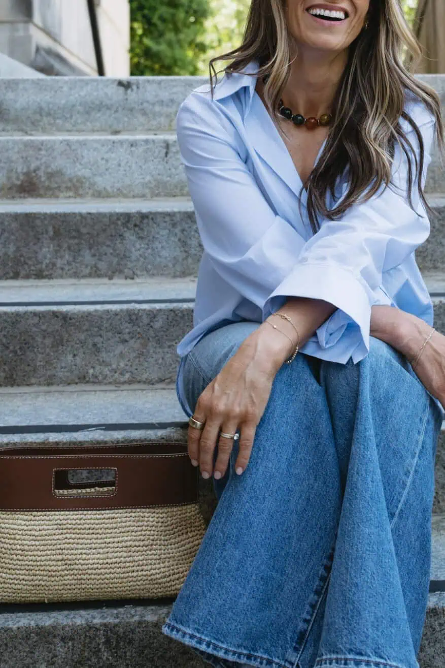 TeriLyn Adams sitting on stairs wearing Next Morning Shirt blue button down with jeans