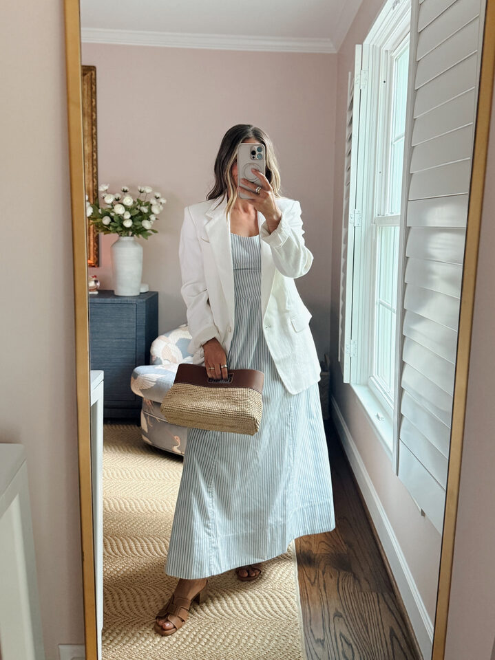 Terilyn adams taking a mirror selfie in a bright, modern room with casual outfit and handbag.