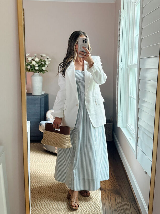 Terilyn adams taking a mirror selfie in a bright, modern room with casual outfit and handbag.