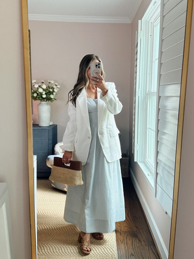 Terilyn adams taking a mirror selfie in a bright, modern room with casual outfit and handbag.