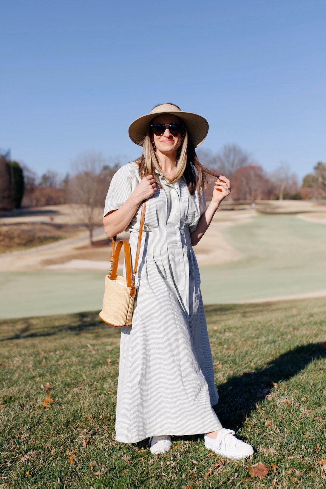 TeriLyn Adams in dress and sunhat with woven bag and white leather veja sneakers