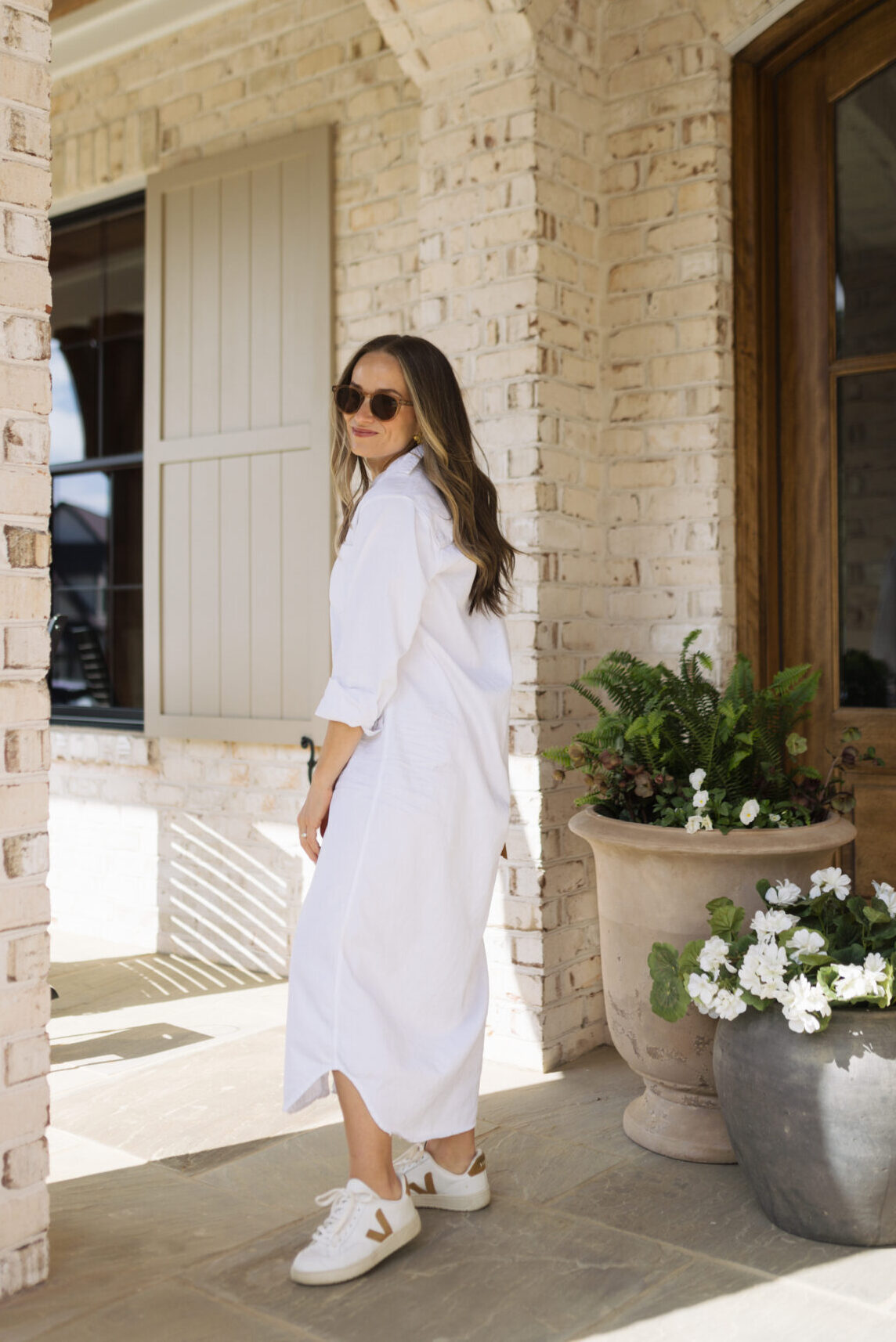 TeriLyn Adams wearing leather vejas sneakers with white dress.