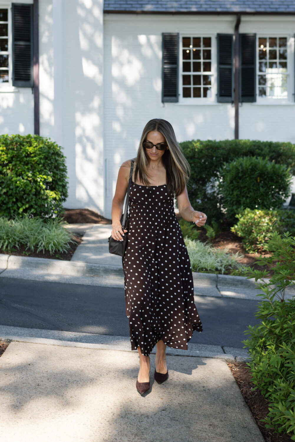 Terilyn adams wearing typescript polka dot dress and heels outside white house for date night.