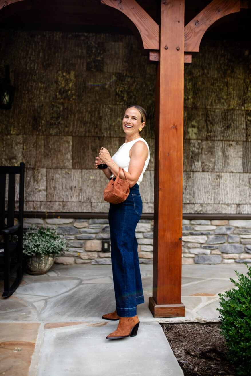 TeriLyn Adams wearing PAIGE Lyra Chelsea boots with wide-leg denim and a white tank top