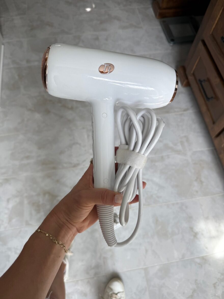 T3 hair dryer with rose gold accents held in hand, product shot