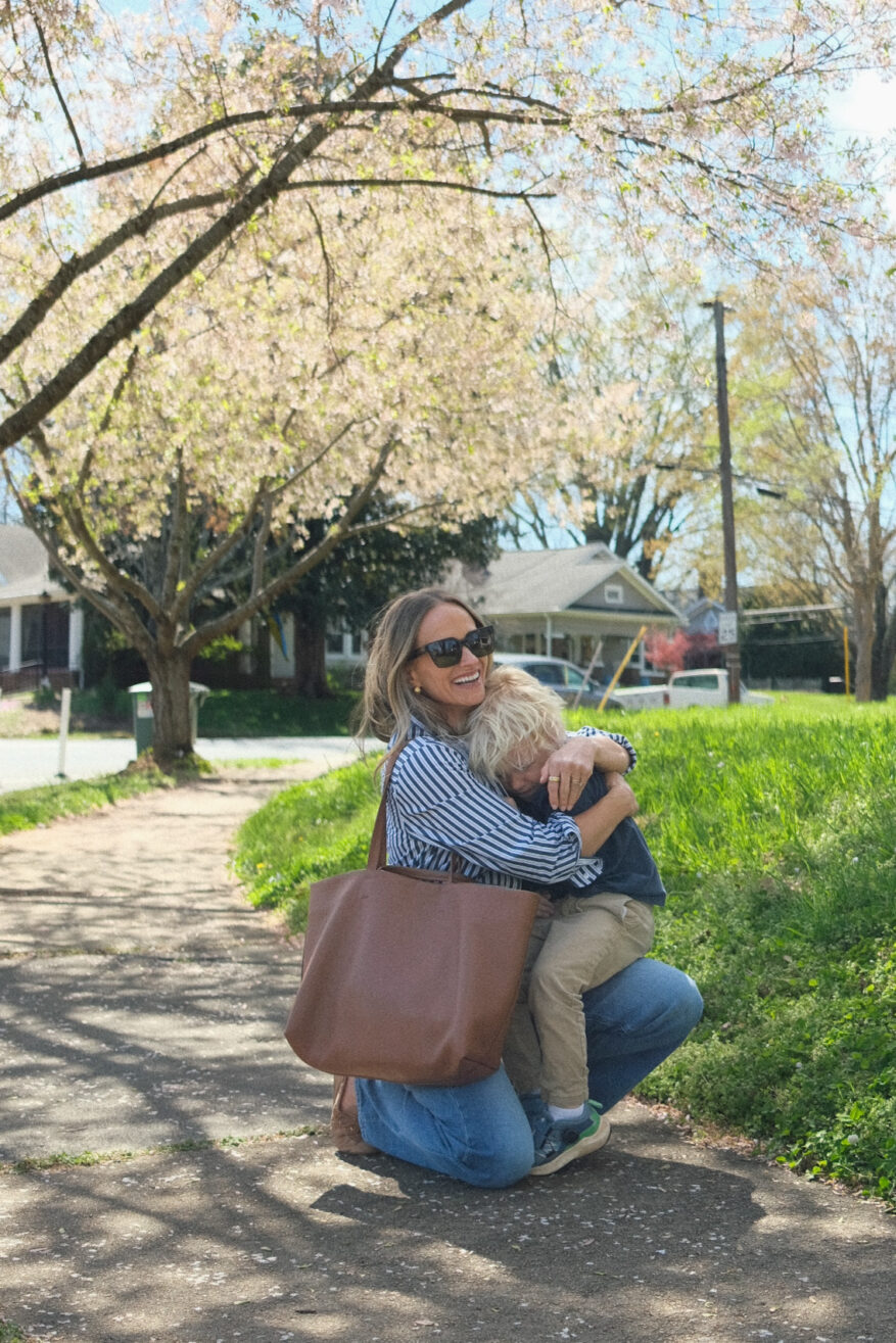 TeriLyn Adams hugging son with Cuyana Classic Easy Tote over shoulder.