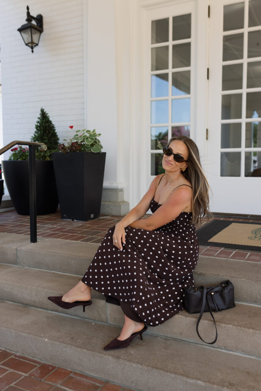 TeriLyn Adams sitting on steps with Cuyana black leather mini dia bag