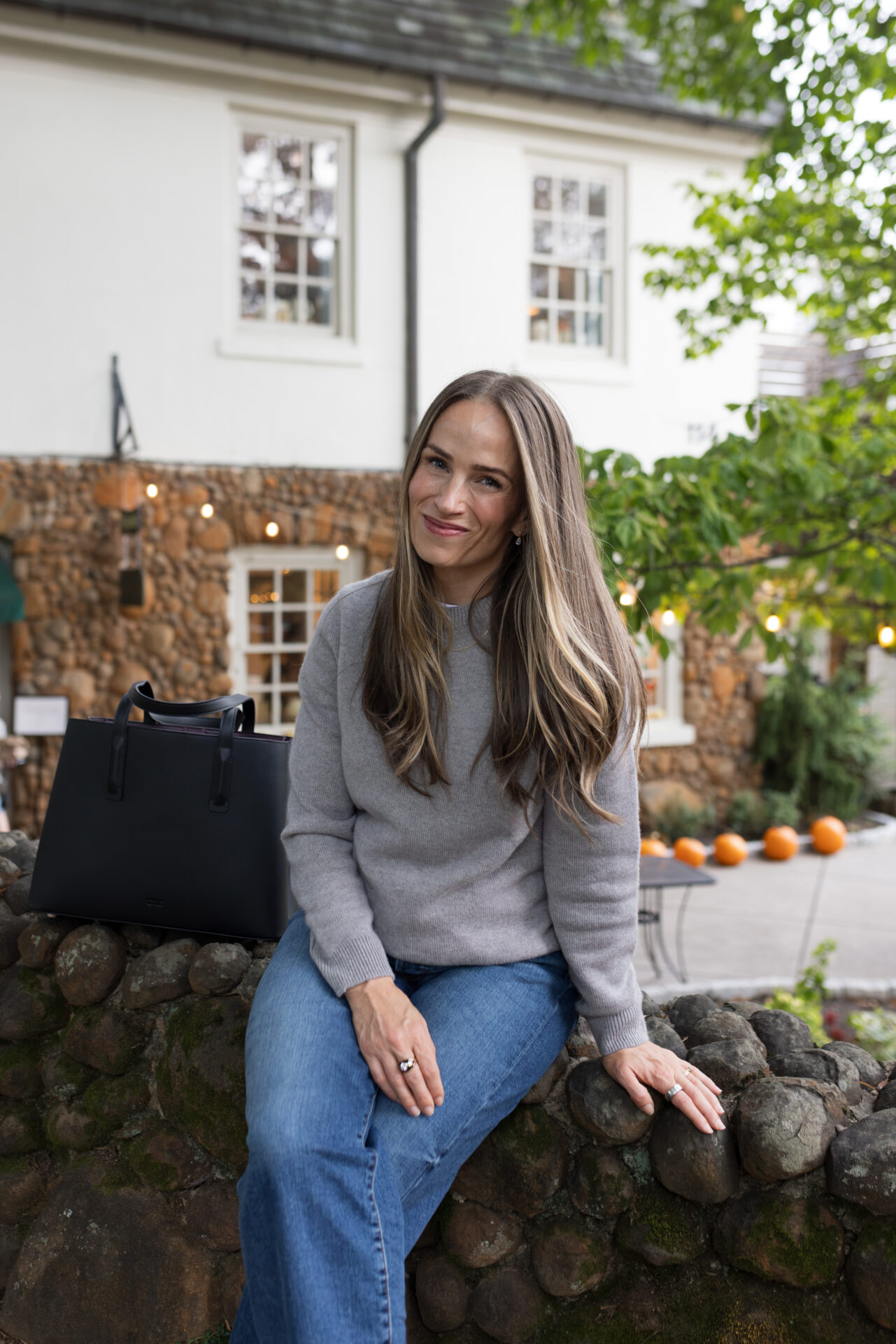 TeriLyn Adams wearing a fine knit sweater with black bag for fall capsule wardrobe outfit ideas.