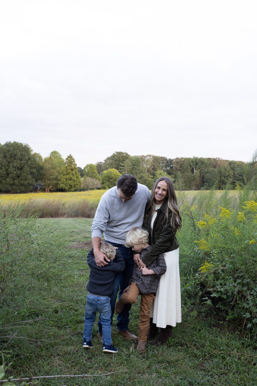 TeriLyn Adams and family posing for family photos while wearing tuckernuck sweater dress and bomber jacket.