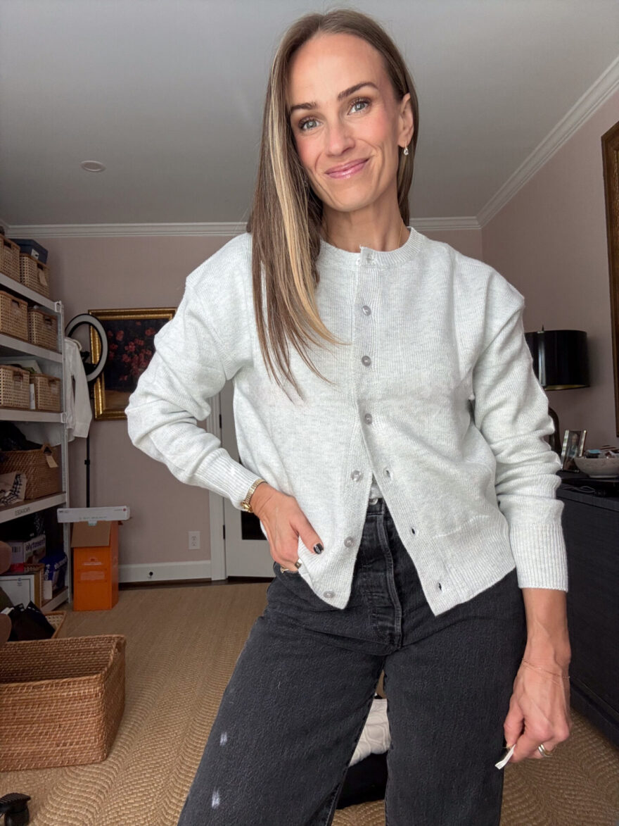 TeriLyn Adams wearing a light gray button-front cardigan with washed black straight-leg jeans