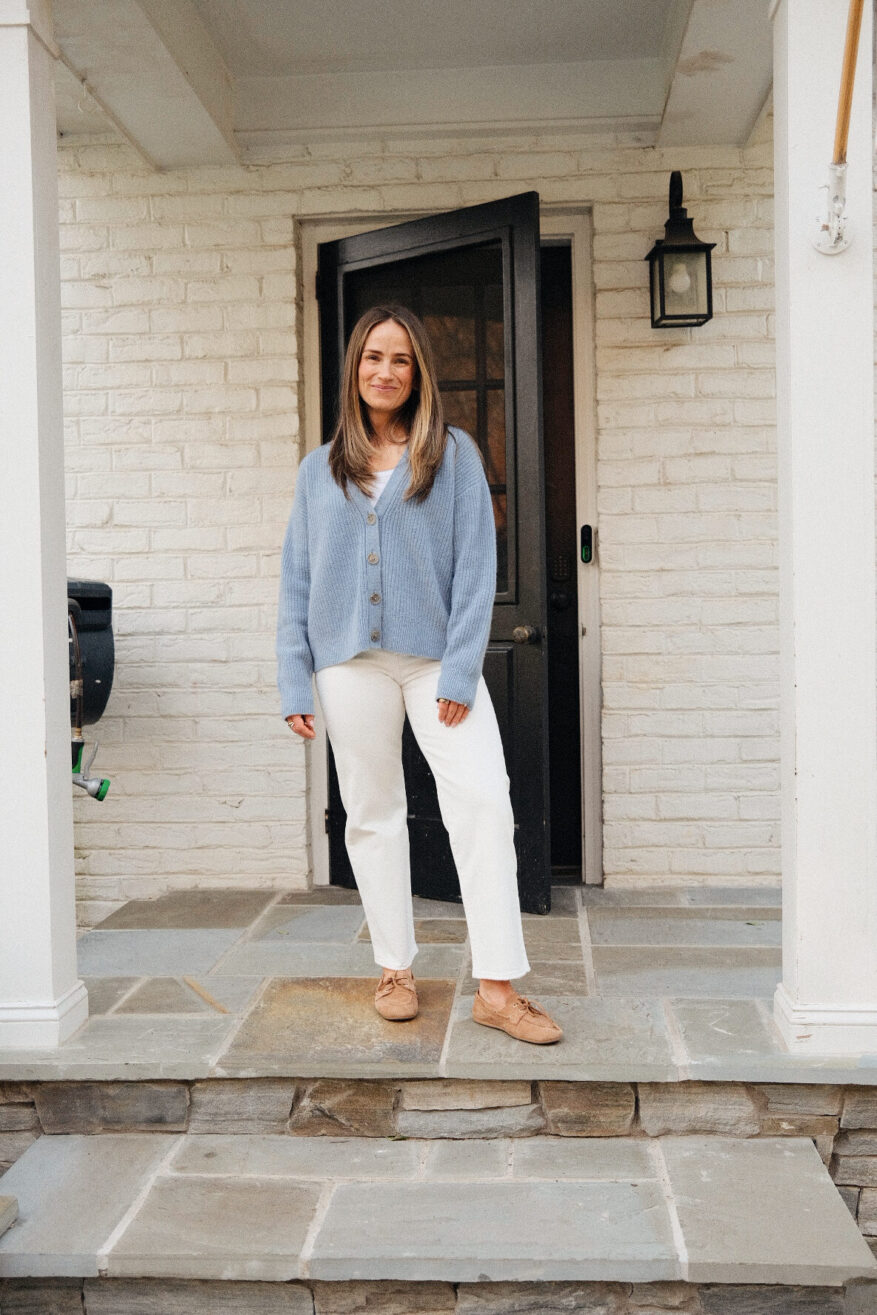 TeriLyn Adams wearing Levi’s Ribcage Straight Ankle jeans in white with a blue cardigan and tan suede boat shoes
